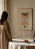 Tableau encadré avec formes géométriques courbes superposées, cercle central pointillé, petite forme ronde, tons beige, sable, blanc cassé et brun taupe, style abstrait bohème. Disponible sur kudeko.com