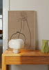 Tableau avec deux vases en lignes noires, fines branches et feuilles sur fond beige chaud, dans un style minimaliste et naturel. Disponible sur kudeko.com
