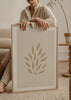 Gerahmtes Wandbild mit abstrakten Blättern in Beige-, Sand- und Cremetönen, botanische Komposition mit klaren organischen Formen, minimalistischer Stil. Erhältlich auf kudeko.com