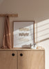Gerahmtes Wandbild mit drei übereinanderliegenden wellenförmigen Flächen in Beige, Taupe und Elfenbein auf weißem Hintergrund, klare Komposition im minimalistischen Stil. Erhältlich auf kudeko.com