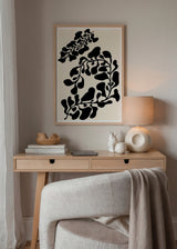 Gerahmtes Wandbild mit schwarzen botanischen Formen, geschwungenen organischen Blättern auf cremefarbenem Hintergrund, minimalistischer Komposition, klarem Kontrast und zeitgenössischem Stil. Erhältlich auf kudeko.com