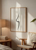 Gerahmtes Wandbild mit weiblicher anatomischer Silhouette in geschwungener schwarzer Linie auf weißem Hintergrund, schlicht, elegant und minimalistisch im modernen Stil. Erhältlich auf kudeko.com