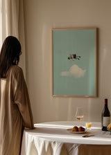 Wandbild mit einem Kind an einer Wäscheleine über einer weißen Wolke, vor klarem himmelblauem Hintergrund, in Schwarz Weiß, mit träumerischem fotografischem und surrealem Stil. Erhältlich auf kudeko.com
