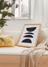 Gerahmtes Wandbild mit vier schwarzen halbkreisförmigen Formen auf weißem Hintergrund, ausgewogener vertikaler Komposition, klarem Kontrast und minimalistischem geometrischem Stil. Erhältlich auf kudeko.com