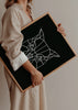 Wandbild mit frontaler Eule, weißen Linien, symmetrischen kantigen Formen, schwarzem Hintergrund und klarem geometrischem Stil in elegantem Look. Erhältlich auf kudeko.com