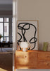 Tableau encadré avec lignes noires épaisses entrelacées sur fond blanc, composition abstraite graphique, contraste marqué et style moderne minimaliste pour décoration murale. Disponible sur kudeko.com