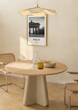 Quadro da Porta de Brandemburgo em Berlim, com colunas monumentais, chão empedrado, céu cinzento e composição urbana a preto e branco, de estilo elegante e intemporal. Disponível em kudeko.com