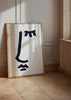 Gerahmtes Wandbild mit abstraktem blauschwarzem Symbol auf weißem Hintergrund, breiten Strichen, lockeren Formen und minimalistischem Stil. Erhältlich auf kudeko.com