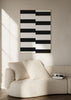 Cuadro decorativo de estilo minimalista y blanco_y_negro colocado en salón, composición geométrica de escalones en blanco y negro, modelo Escalones I