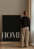 Cuadro decorativo de estilo minimalista y blanco_y_negro colocado en salón, Lámina tipográfica Home en blanco y negro, modelo Home Black
