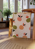 Gerahmtes Wandbild mit Orangen und Blättern in schlichten Formen, in Koralle, Pfirsich, Olivgrün, Rot und Schwarz auf beigem Hintergrund, minimalistischer Stil. Erhältlich auf kudeko.com