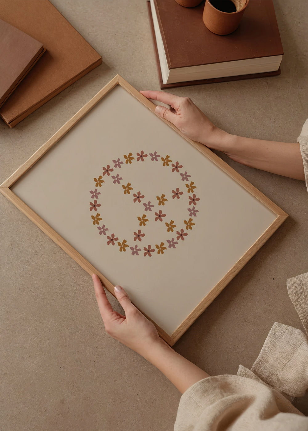 Gerahmtes Wandbild mit Friedenssymbol aus kleinen Blumen in Altrosa, Terrakotta und Senfgelb auf hellbeigem Hintergrund, gestaltet im klaren nordischen Stil. Erhältlich auf kudeko.com