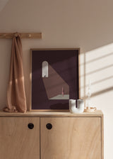 Tableau encadré avec femme debout sous un rayon de lumière, fenêtre en arche, petit oiseau, fond bordeaux, tons rose poudré, beige et style minimaliste contemporain. Disponible sur kudeko.com