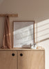 Gerahmtes Wandbild mit mehreren weißen Herzen in freier Linienführung auf hellbeigem Hintergrund, klare Komposition, sanfte Farben und minimalistischer Stil mit ruhiger romantischer Note. Erhältlich auf kudeko.com