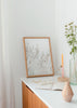 Cuadro decorativo de estilo minimalista y nórdico colocado en dormitorio, flores blancas etéreas de invierno, modelo Flores Invernales Blancas