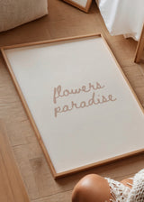 Gerahmtes Wandbild mit dem Schriftzug flowers paradise, handschriftliche Typografie in Altrosa auf weißem Hintergrund, klarer Stil und moderne Wanddekoration. Erhältlich auf kudeko.com