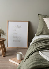 Gerahmtes Wandbild mit dem Spruch beige is my happy color, weiche beigefarbene Serifenschrift auf weißem Hintergrund, minimalistischer Stil, klare Komposition und neutrale Farbwirkung. Erhältlich auf kudeko.com
