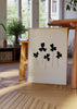 Wandbild mit fünf schwarzen Blumen, abgerundeten Blütenblättern, feinen Stielen, hellbeigem Hintergrund und klarer Komposition im minimalistischen Stil. Erhältlich auf kudeko.com