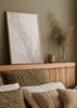 Gerahmtes Wandbild mit Zweigen getrockneter Blumen in Off-White, Creme und hellem Beige, vor hellem Hintergrund und mit ruhigem floralem Stil für natürliche Wandgestaltung. Erhältlich auf kudeko.com
