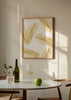 Gerahmtes Wandbild mit länglichen tropischen Blättern in Gold auf weißem Hintergrund, leichte, helle und klare Komposition im minimalistischen Stil für moderne Räume. Erhältlich auf kudeko.com