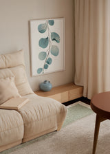 Cuadro decorativo de estilo minimalista y orgánico colocado en salón, rama botánica en acuarela azul verdosa, modelo Acuarela Floral II
