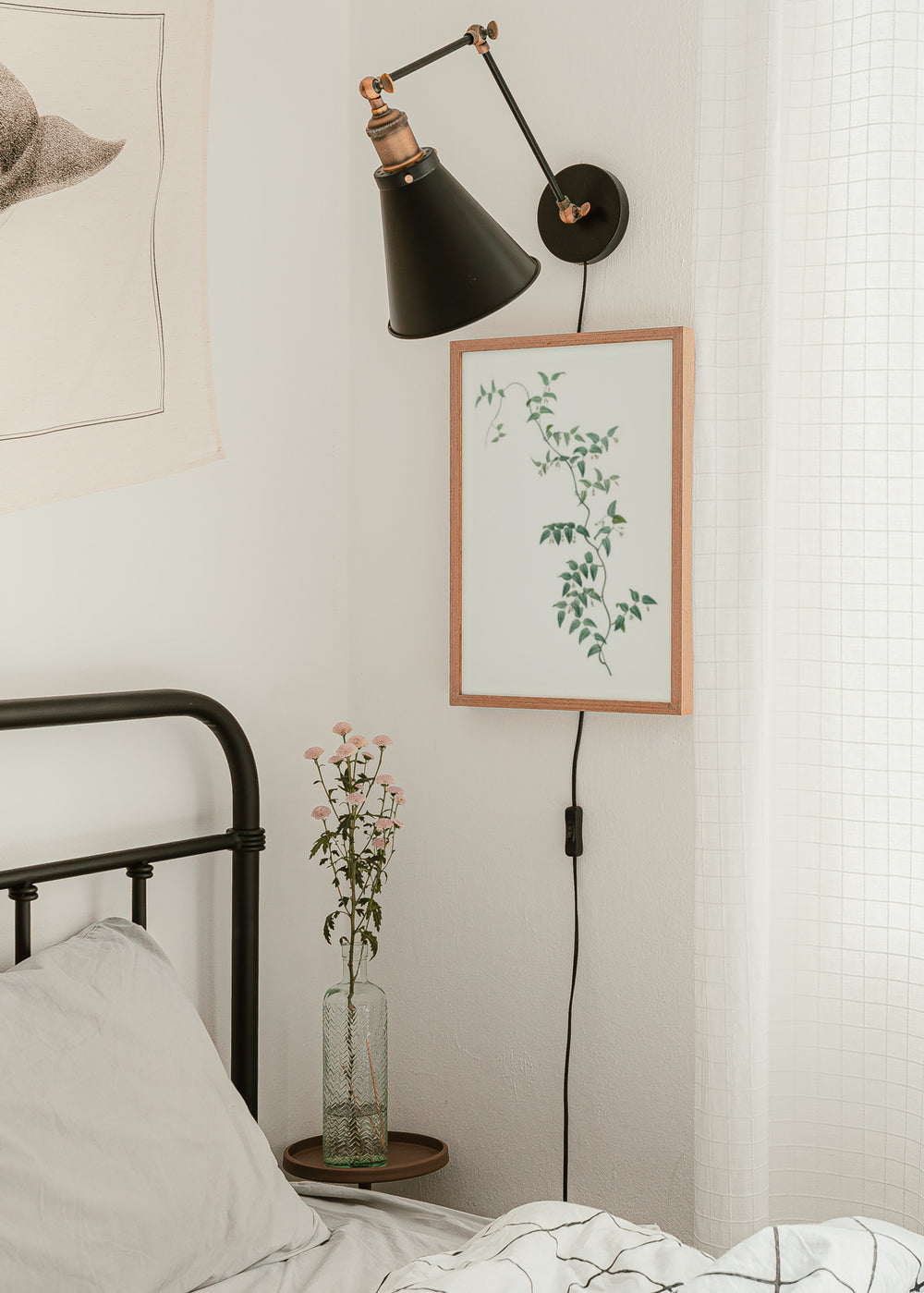 Gerahmtes Wandbild mit kletterndem Zweig, sanft grünen Blättern, feinen Stielen, kleinen weißen Blüten, hellem Hintergrund und floralem Stil für natürliche Räume. Erhältlich auf kudeko.com