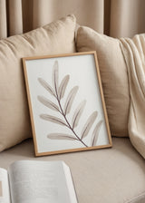 Cuadro decorativo de estilo minimalista y orgánico colocado en salón, rama botánica en tonos grises suaves, modelo Rama Gris