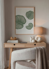 Cuadro decorativo de estilo minimalista y orgánico colocado en salón, hojas tropicales minimalistas en verde salvia, modelo Tropical Dream Leaves
