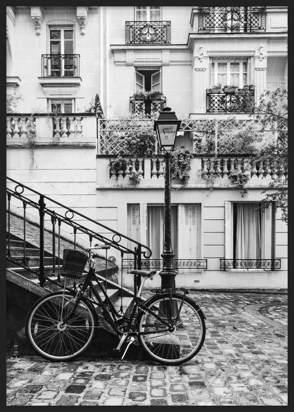 Cuadro de calle parisina en blanco y negro con bicicleta, farola, balcones clásicos, escalinata de hierro, fachadas elegantes y ambiente fotográfico. Disponible en kudeko.com