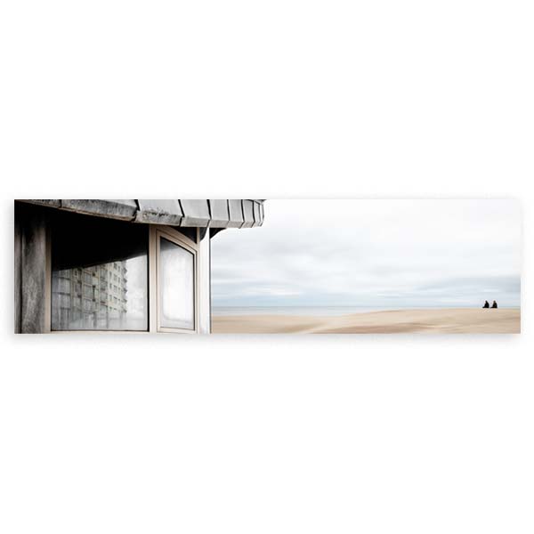 Cuadro horizontal de una construcción junto a una playa vacía, con cielo suave azul grisáceo, arena clara y composición panorámica de estilo fotográfico. Disponible en kudeko.com