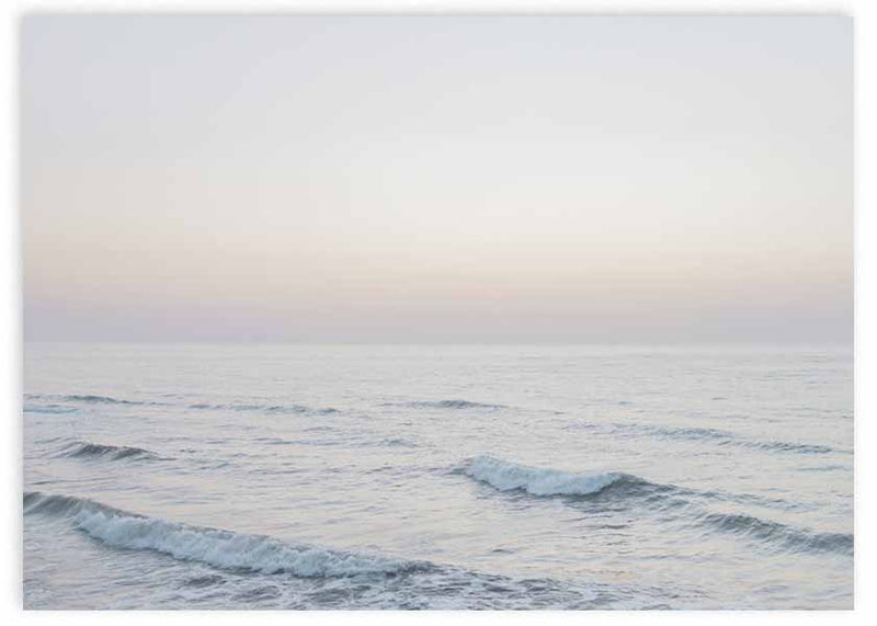 Quadro horizontal com mar calmo ao amanhecer, ondas suaves, horizonte limpo, tons de bege, rosa pálido e azul acinzentado, em estilo natureza e paisagem. Disponível em kudeko.com