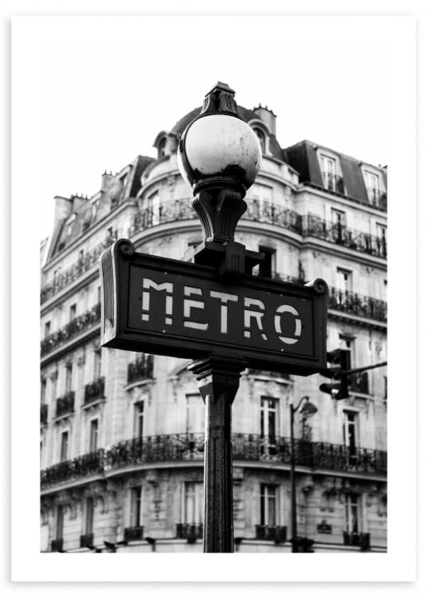 Quadro emoldurado com letreiro do metro de Paris em primeiro plano, fachada clássica parisiense ao fundo, tons de preto, cinzento e branco, estilo urbano fotográfico. Disponível em kudeko.com