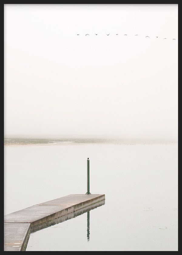 Cuadro de paisaje costero con muelle de cemento sobre agua tranquila, cielo brumoso, aves lejanas y tonos blanco roto, gris suave y beige, de estilo naturaleza y paisajes. Disponible en kudeko.com