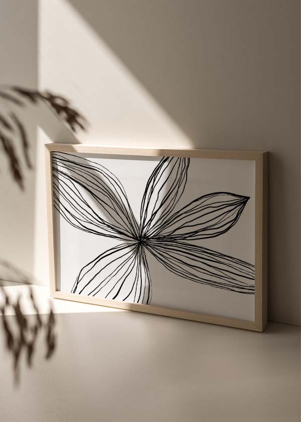 Cuadro horizontal con gran flor de pétalos alargados en líneas negras sobre fondo blanco, composición limpia de estilo minimalista. Disponible en kudeko.com