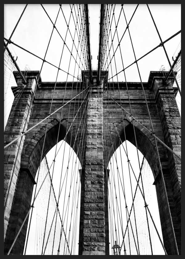 Cuadro del Puente de Brooklyn en blanco y negro, con arcos de piedra, cables tensos, composición simétrica y estilo fotográfico urbano. Disponible en kudeko.com