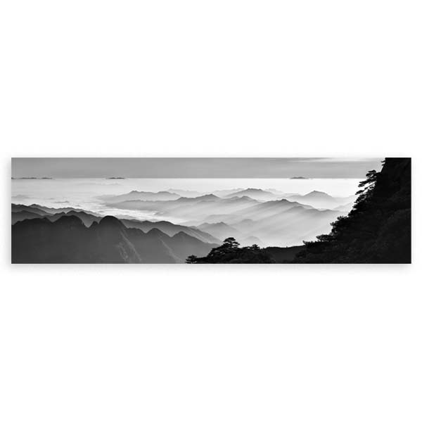 Cuadro horizontal de montañas envueltas en niebla, con picos lejanos, árboles oscuros, capas de bruma en blanco, gris y negro, de estilo naturaleza y paisajes. Disponible en kudeko.com