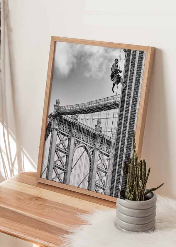 decoración con cuadros, ideas - lámina decorativa fotográfica en blanco y negro de obrero colgado sobre edificio de Brooklyn - kudeko