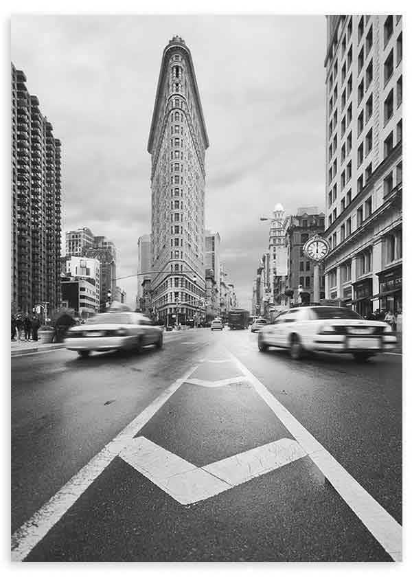 Quadro emoldurado de avenida urbana a preto e branco com edifício triangular, carros em movimento, perspetiva central e estilo fotográfico arquitetónico. Disponível em kudeko.com
