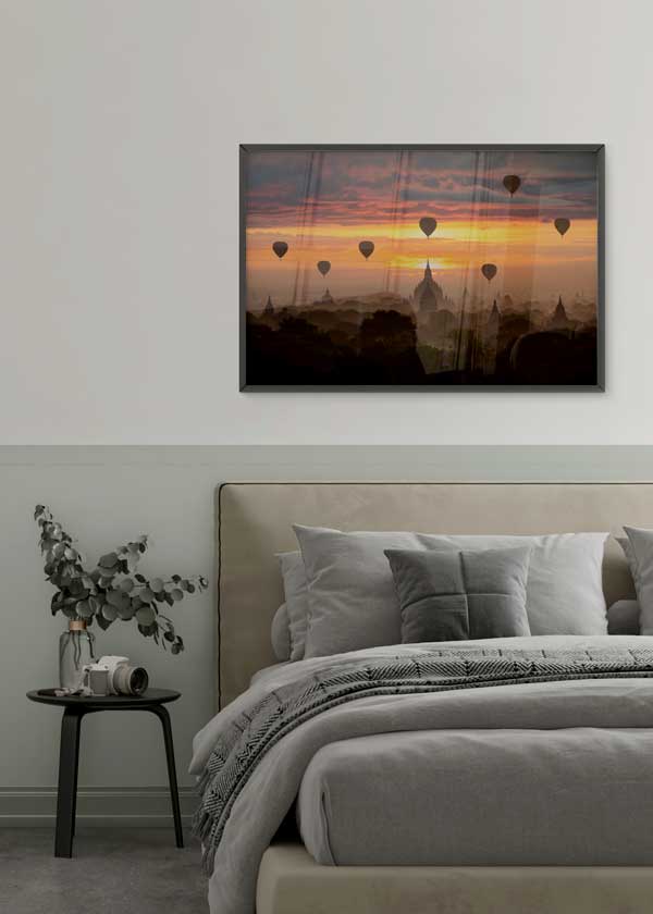 Cuadro horizontal de templos de Bagan entre neblina al amanecer con globos aerostáticos, cielo naranja, dorado y violeta, estilo fotográfico. Disponible en kudeko.com