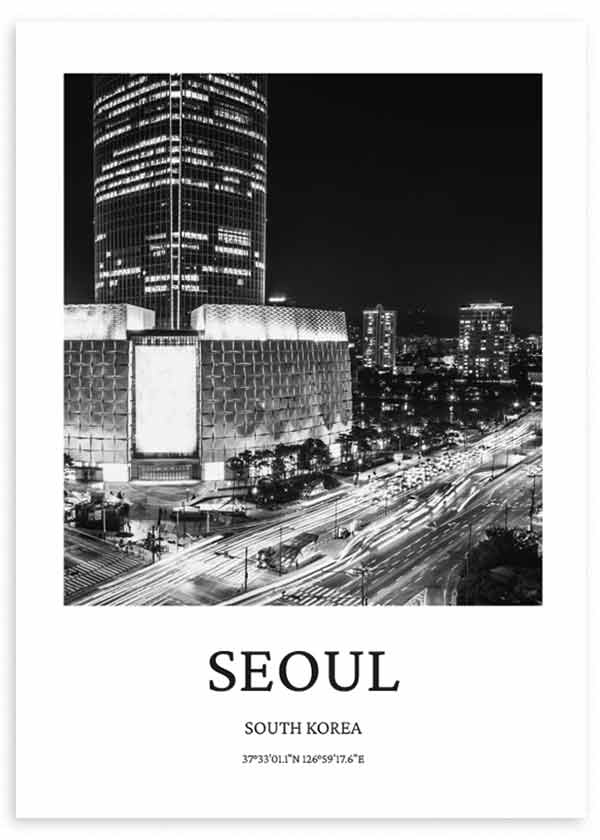 Tableau encadré avec vue nocturne de Séoul, gratte-ciel illuminé, grande avenue aux traînées lumineuses, immeubles urbains en noir et blanc, style photographique élégant et cosmopolite. Disponible sur kudeko.com