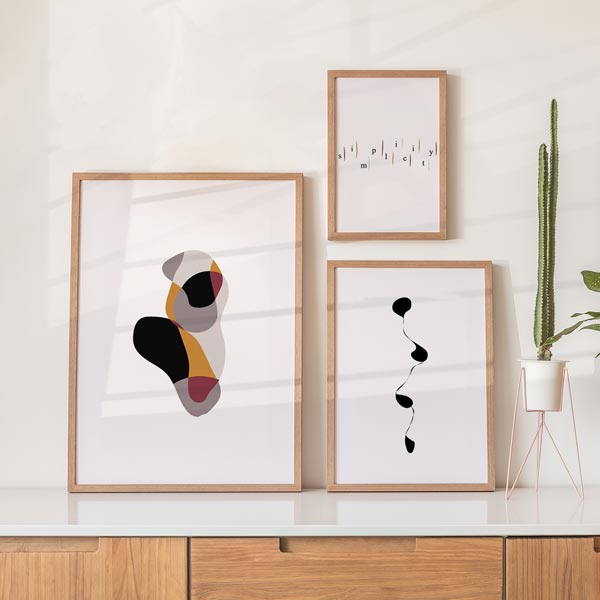 Set aus drei gerahmten Wandbildern mit abstrakten organischen Formen, Typografie simplicity, minimalistischer fließender Linie, in Schwarz, Beige, Terrakotta und Bordeaux, mit ruhigem abstraktem Stil. Erhältlich auf kudeko.com