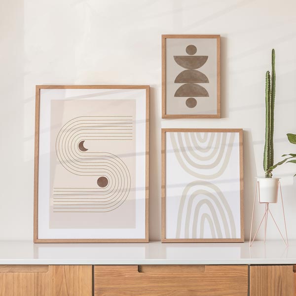 Set aus drei Wandbildern mit beigen Bögen, durchgehenden geschwungenen Linien, halbkreisförmigen Elementen in sanftem Braun auf hellem Grund und ausgewogener geometrischer Gestaltung. Erhältlich auf kudeko.com