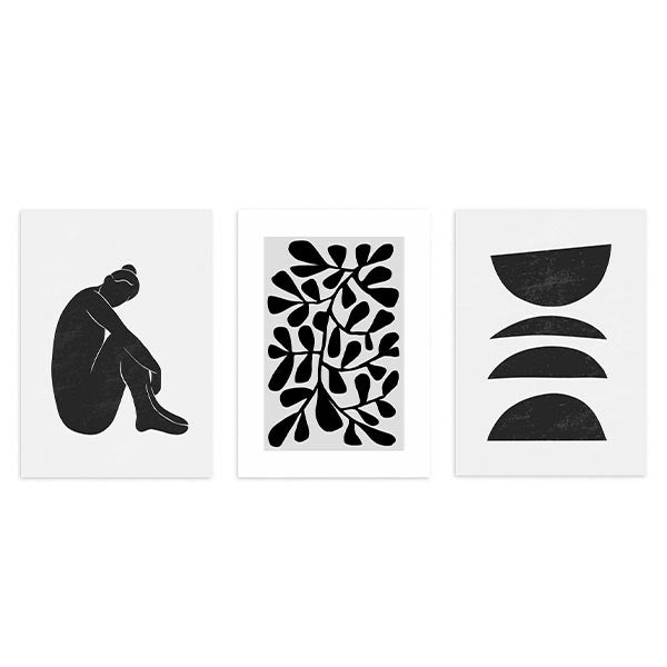 Conjunto de tres cuadros con figura femenina negra, composición botánica abstracta y formas semicirculares en blanco y negro, de estilo minimalista. Disponible en kudeko.com